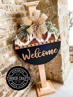 a welcome sign in front of a brick wall with a wreath on it and the words timber crafts next to it