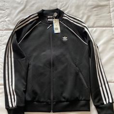 Adidas Women Superstar Three Stripe Track Jacket Black Size Medium New With Tags Adidas Long Sleeve Track Jacket With Three Stripes, Casual Black Varsity Jacket With Zipper, Black Casual Varsity Jacket With Zipper, Casual Black Varsity Jacket With Zipper Closure, Black Casual Varsity Jacket With Zipper Closure, Adidas Fitted Track Jacket For Streetwear, Fitted Outerwear With Three Stripes For Streetwear, Black Track Jacket With Zipper Closure For Spring, Spring Black Track Jacket With Zipper Closure