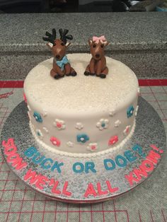 there is a cake decorated with two deer figurines