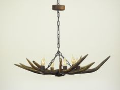 a chandelier made out of antlers with candles hanging from the middle one