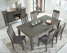 a dining room table with chairs and plates on top of it in front of a window