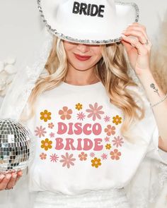 a woman wearing a disco hat and holding a disco ball in front of her face