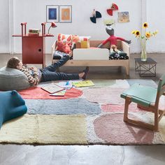 a man laying on the floor in front of a living room filled with furniture and decor