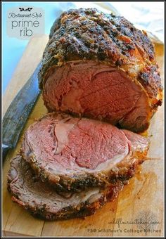 sliced meat on a cutting board next to a knife