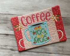 a coffee mug is embroidered onto a red and pink patchwork piece with the words coffee hug inside