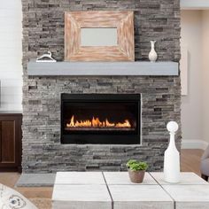 a living room filled with furniture and a fire place in front of a stone fireplace