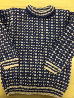 a blue and white sweater sitting on top of a wooden table