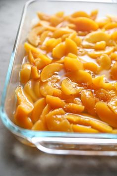 a glass casserole dish filled with sliced peaches