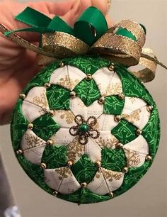 a green and white ornament with gold trim