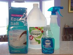 bottles of cleaning products sitting on top of a counter next to a bag of toilet paper