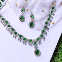 Discover the allure of artisan craftsmanship with this Handmade Emerald Green Crystal Necklace Set. Skillfully crafted with attention to every detail, this set features a stunning silver-plated necklace adorned with vibrant green crystals and matching earrings. Each piece is designed to add a touch of elegance and sophistication to your ensemble, making it perfect for weddings, parties, and special occasions. Materials: Silver-Plated Metal: Handcrafted with premium silver plating, offering both Hand Set Emerald Necklaces For Formal Occasions, Formal Hand Set Emerald Necklaces, Formal Hand Set Emerald Necklace, Formal Hand-set Emerald Necklaces, Green Sparkling Stones Jewelry Sets For Wedding, Hand Set Emerald Necklace For Celebration, Cubic Zirconia Necklace For Party, May Birthstone, Formal Bridal Necklace With 17 Jewels And Emerald, Fine Jewelry With Stone Setting For Wedding