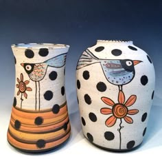 two ceramic vases with birds and flowers painted on them