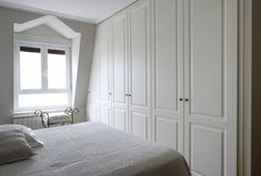 a bedroom with white closets and bed in it