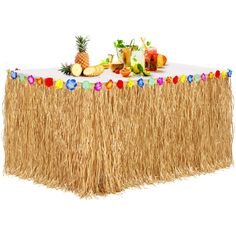 a table topped with a straw skirt and fruit