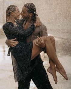 two people hugging each other in the rain