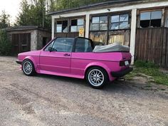 a pink car parked in front of a building