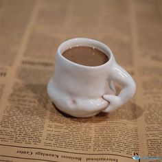 a coffee cup sitting on top of a newspaper