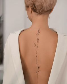 the back of a woman's neck with tattoos on it