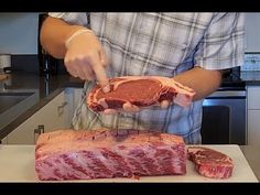 a man cutting up meat on top of a counter