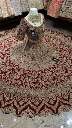 a mannequin sitting on top of a red and gold rug in a store