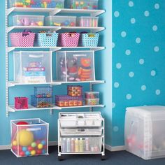 a room with blue walls and white shelves filled with plastic bins, toys and other items