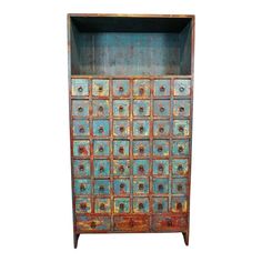 an old wooden cabinet with many drawers and knobs on the doors is painted blue