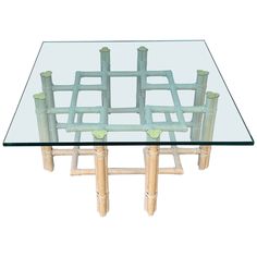 a glass table topped with bamboo sticks and a square glass top on an isolated white background