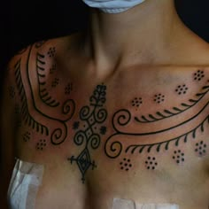 a man with tattoos on his chest wearing a surgical mask