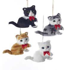 four ornaments in the shape of cats hanging from strings