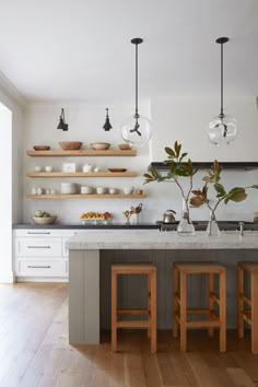 a kitchen with two wooden stools next to an island