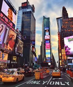 a busy city street filled with lots of traffic and tall buildings in new york, ny