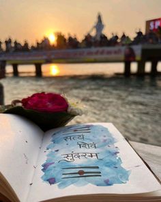 an open book sitting on top of a wooden table next to a body of water