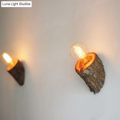 three light bulbs are on the wall next to a piece of driftwood that has been turned into a lamp