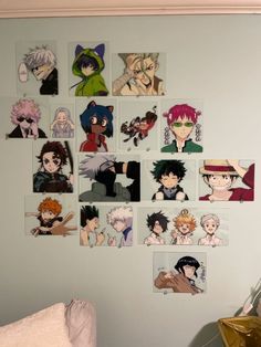 a bunch of anime pictures hanging on the wall above a bed in a room with white walls