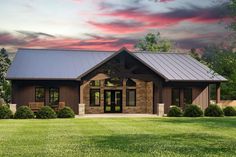 a house with a metal roof in the middle of a grassy field at sunset or dawn