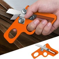 an orange pair of scissors being held by someone's hand with the blades open