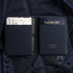 a passport case sitting on top of a blue jacket with water droplets all over it