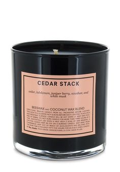 a black candle with an orange label on it