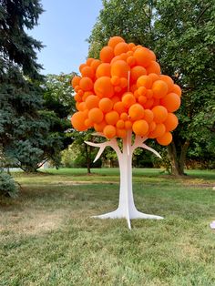 an orange balloon tree in the middle of a park