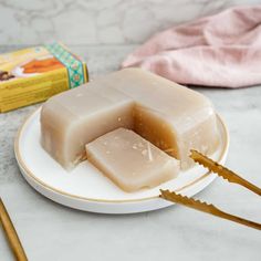 two pieces of soap sitting on top of a white plate next to a box of toothbrushes