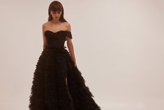 Spectacular frill-layered ball gown in black that will become a timeless wardrobe item. Featuring a one-shoulder heart-shaped neckline, a semi-transparent corset with lace-up closure on the back, and a stunning frill-layered volumetric maxi tulle skirt with a long train. Details: Material: Tulle Fabric Composition: 100% polyester Sleeves style: Sleeveless one-shoulder Silhouette: Princess dress Skirt length from waist: 115 cm Neckline: Heart-shaped neckline Back: Lace-up corset Built-in cups Lin Transparent Corset, Maxi Tulle Skirt, Milla Dresses, Tulle Maxi Skirt, Sleeves Style, Timeless Wardrobe, Princess Ball Gowns, Long Train, Tulle Fabric