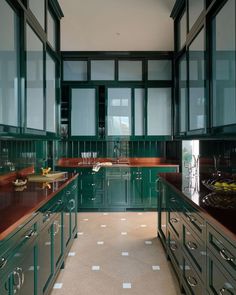 a kitchen with green cabinets and white flooring