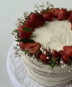 a white cake with strawberries and flowers on top