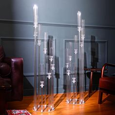 two clear vases sitting on top of a wooden table next to a brown chair