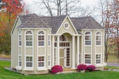 a small house with windows and flowers in the front yard