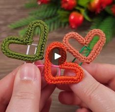 two small crocheted hearts being held by someone