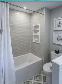 a bathroom with white fixtures and gray walls