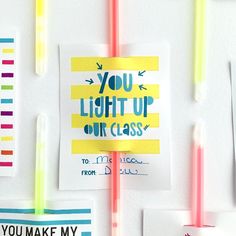 some stickers are hanging on the wall with different colors and shapes, including one that says you light up our class