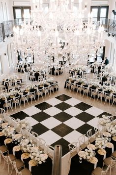 an overhead view of tables and chairs with chandelier in the center, surrounded by black and white checkered flooring