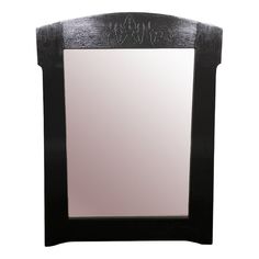 a black wooden mirror sitting on top of a white wall